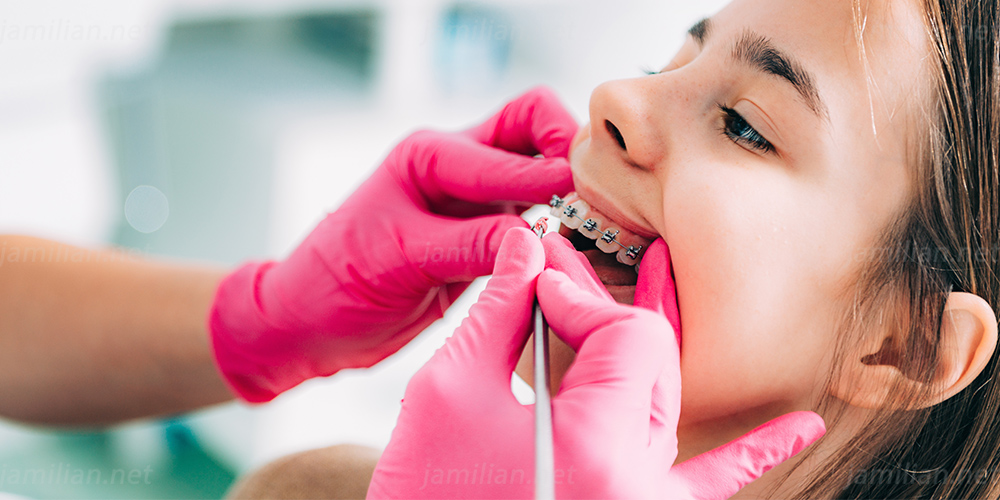 orthodontist-checking-girl-s-dental-braces