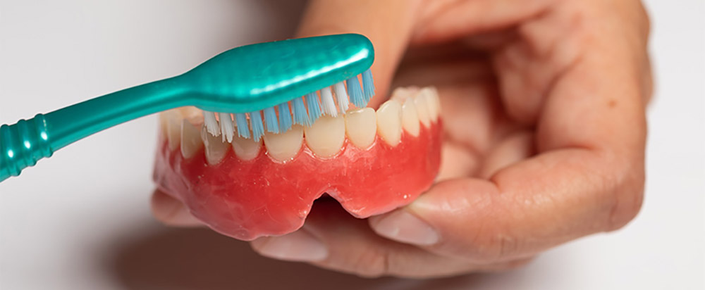 caring for dentures by brushing