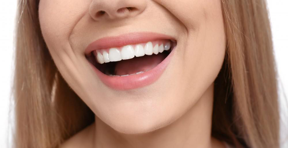 Eine Frau mit geraden und schönen Zähnen