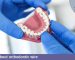 يقوم طبيب الأسنان بتثبيت الأسنان على نموذج فك صناعي بأسلاك تقويم الأسنان