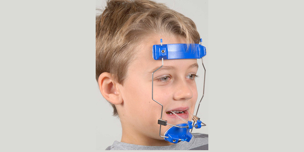 a boy using a headgear for maxillary orthodontic treatment