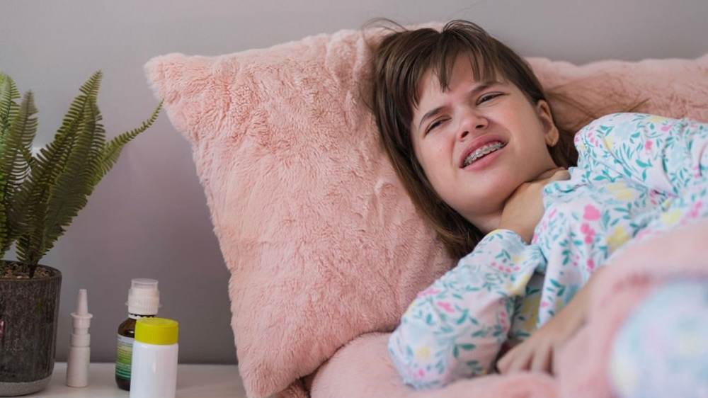 دختری با دندان های ارتودنسی شده که از درد تیروئید رنج میبرد