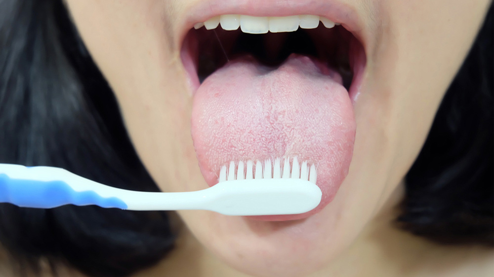 woman who brushing tongue to get rid of mouth bitterness
