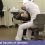 دندانپزشک نشسته روی صندلی با کمر خمیده در حال معاینه بیمار