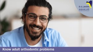 مرد خندان با ارتودنسی روی دندان هاش و عینک بر روی چشمانش و موهای بلند