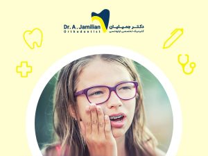girl with purple glasses and orthodontics placed her hand on her face due to toothache