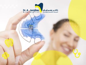 خانمی با لبخند که پلاک ارتودنسی متحرک در دست دارد.